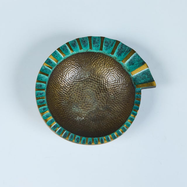 A heavy, cast bronze ashtray by Maurice Ascalon in a nautilus shape has a fluted, flat edge that widens as it spirals...