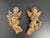 Presenting a pair of gilt gesso cherub wall hangings, each cherub holding a floral spray in hand. Dating back to the early...