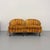 A charming pair of vintage barrel back lounge chairs featuring softly curved silhouettes upholstered in warm earth-toned...