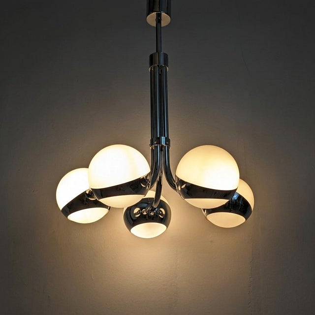 A mid-century modern chandelier, inspired by the designs of the Italian firm Stilnovo, from the 1960s. The architectural...