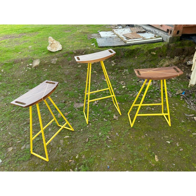 This sleek stool has a thin carved wooden seat that rests on a steel tubing base. The elegant seat is curved for seamless...