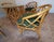 A refined mid-century rattan dining set attributed to Ficks Reed, featuring four barrel-back dining armchairs and a round...