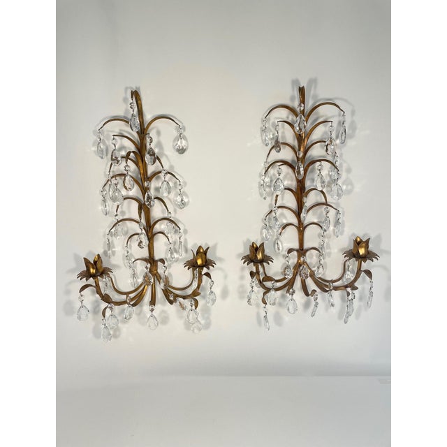 A fabulous pair of Italian Gilded Tole Two-Arm Candle Sconces with 33 eye catching crystal prisms on each sconce. Circa...