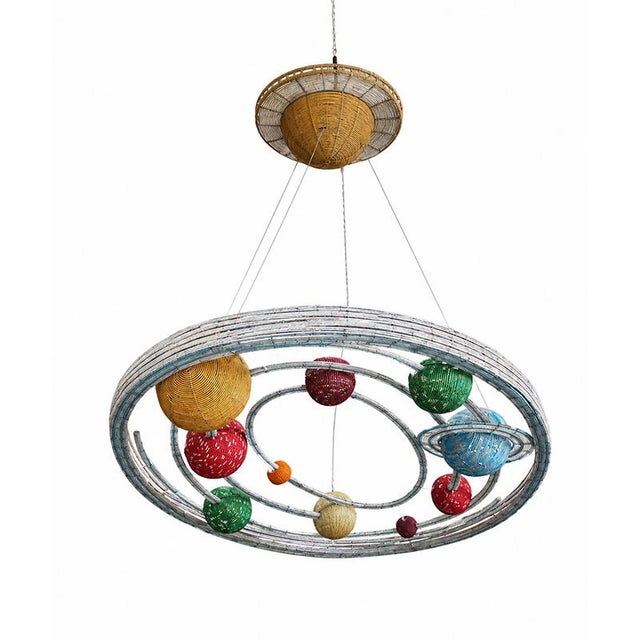 A strikingly dramatic, suspended, illuminated solar system, crafted with concentric orbits and intertwined planets in...