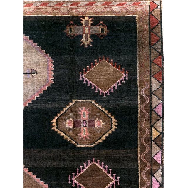 This Mid-20th century Turkish Anatolian room-size carpet presents a bold geometric composition arranged across a deep...