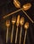 Gold-plated stainless steel flatware by Stanley Roberts, made in Japan. The handles are shaped like bamboo stalks, with...