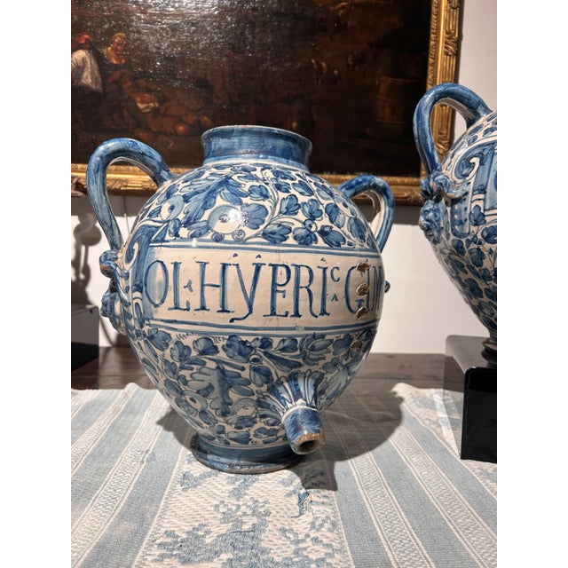 This beautiful pair of globular-shaped pharmacy jars have two handles and an element that is quite unusual for this type...