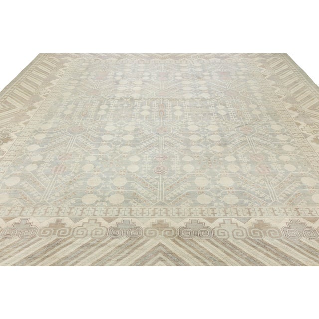 This hand-knotted wool rug reinterprets East Turkestan Khotan motifs for contemporary spaces. Its intricate geometric...