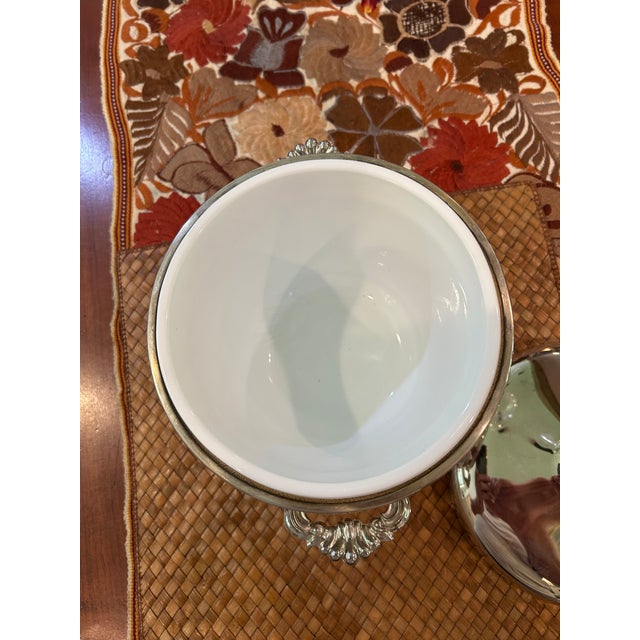 This is a vintage F.B. Rogers silver-plated ice bucket with a white glass liner. It features an ornate, scrolled handle on...
