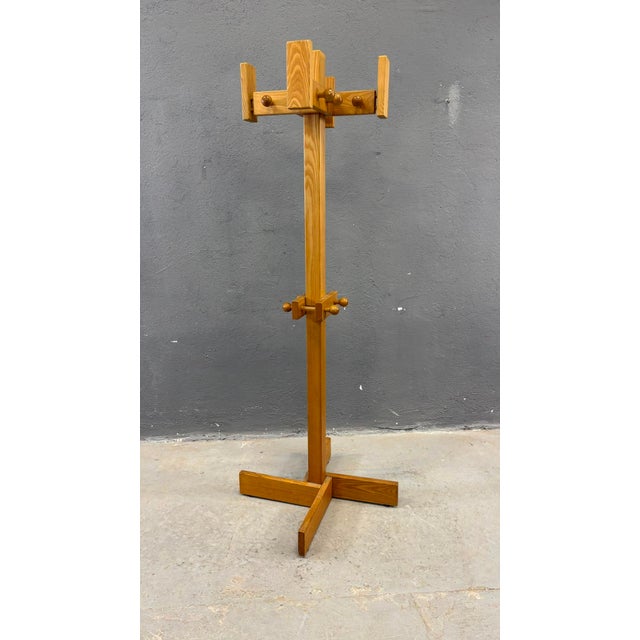 A practical and sculptural freestanding coat rack crafted from solid pine, featuring a clean geometric silhouette and...