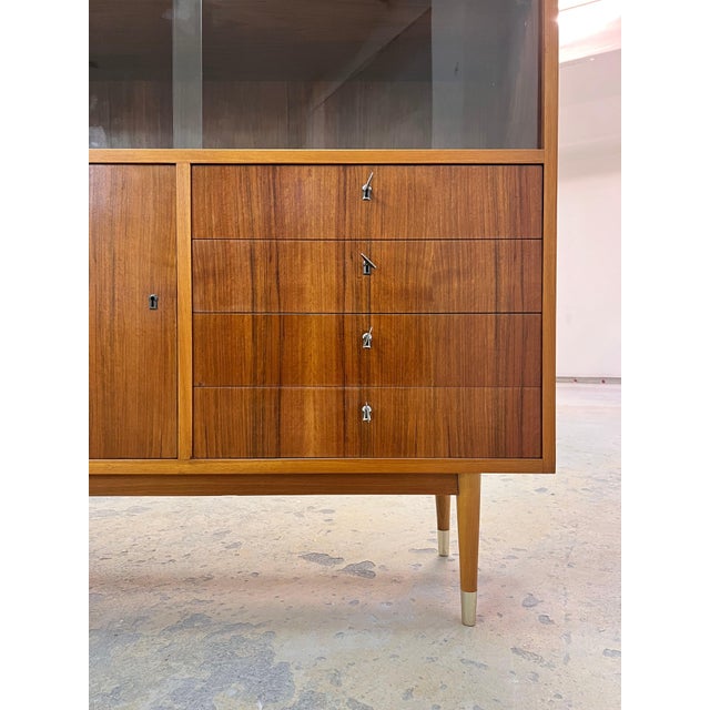 An elegant, fully restored highboard from Deutsche Werkstätten Hellerau, crafted in walnut. This piece impresses with its...