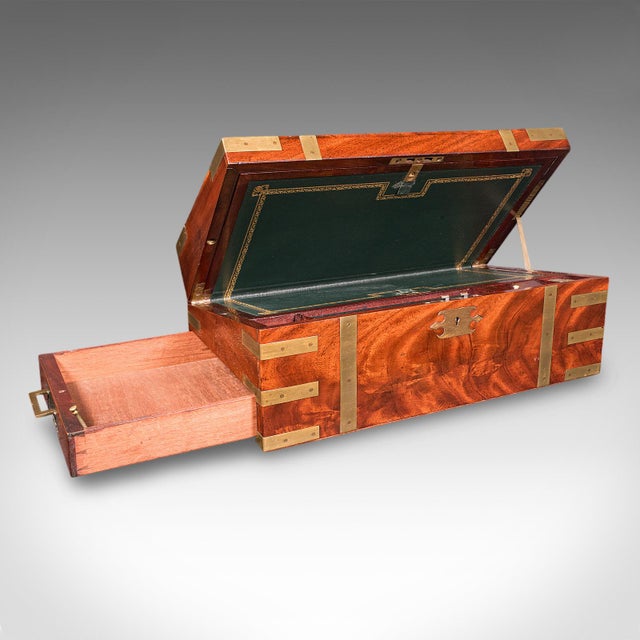 This is an antique campaign writing slope. An English, mahogany and brass correspondence box with leather skiver and book...