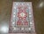 Hand-knotted Pakistani Kazak wool rug featuring a red field with bold central geometric medallions and stylized tribal...