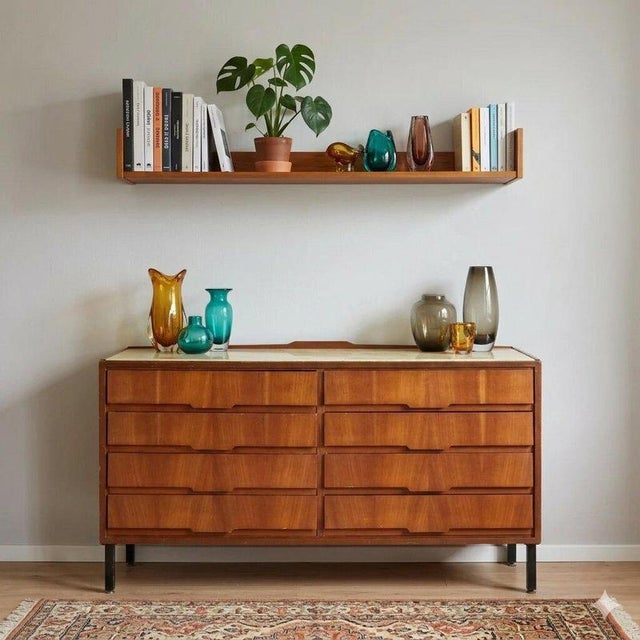 Eight-drawer chest of drawers in mahogany veneer, the top is made of back-treated glass with a marble effect, the legs are...