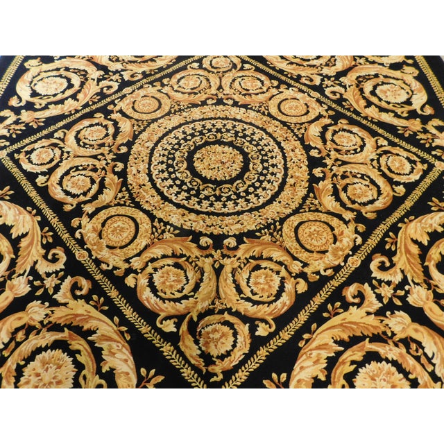 Hand knotted black and gold rug in wool pile on cotton foundation.