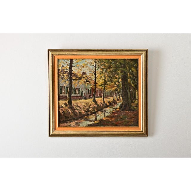 An enchanting French vintage oil on canvas painting that depicts a quaint, autumnal scene of a small village along a...