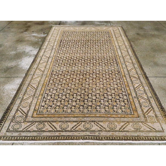 A vintage Persian Malayer Gallery carpet. The chocolate field features a geometric small boteh pattern and similarly...