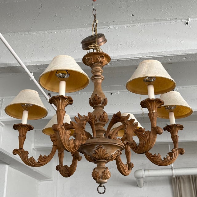 This late 20th century Italian Baroque style chandelier features a 30" diameter carved wood body with six arms. The...