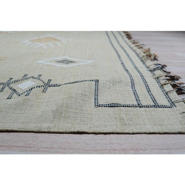 This hand-knotted pile rug features a primary color palette consisting of ivory, beige, cream, and white tones. Made from...