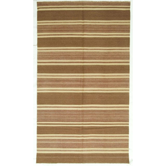 A vintage Turkish Kilim runner handwoven in the 1940s, featuring timeless stripes that blend effortlessly into both modern...
