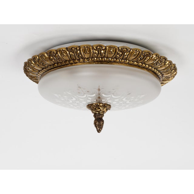 A vintage flush mount 2-light fixture made of brass with a frosted glass patterned lampshade. Spain circa 1960s....