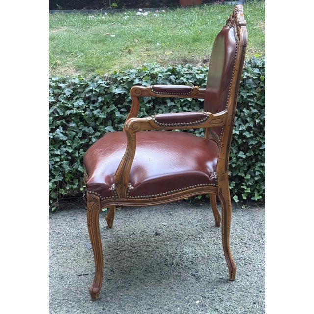 Gorgeous armchair with a rustic frame and carved details, leather upholstery with studded trim, cabriole legs. Leather...