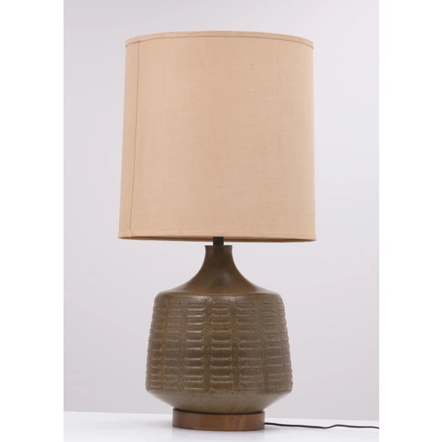An impressive David Cressey for Architectural Pottery lamp. The glaze is a semi-gloss dark green with speckled brown on...