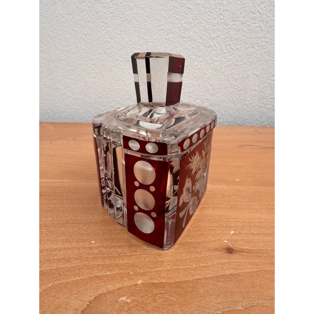 Striking and sophisticated, this antique Bohemian trinket box dates to the 1920s and showcases the rich ruby red “cut to...