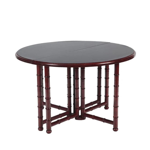 A French faux bamboo dining room table, in the manner of Jansen, C 1960. The expandable, laminate top table accommodates...