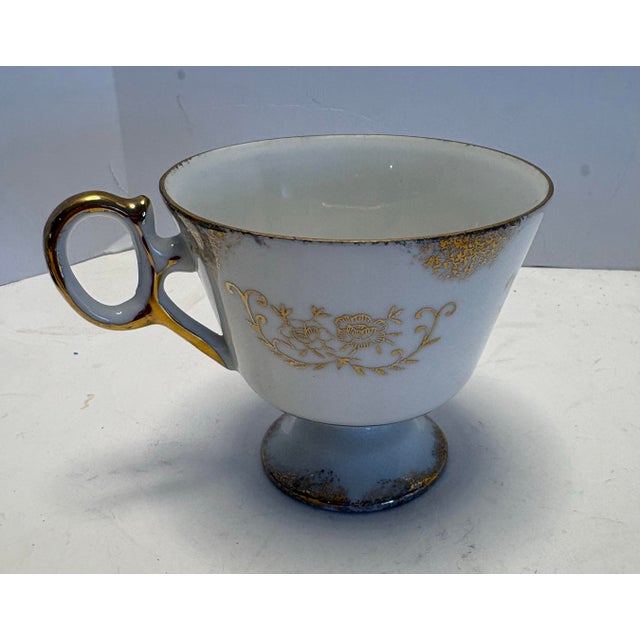 Antique porcelain tea cup featuring ornate raised gilt cartouche decoration over soft lavender enamel panels. Likely of...