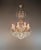 An antique crystal chandelier with an open, elegantly curved structure and rich crystal ornamentation. Stylistically, we...