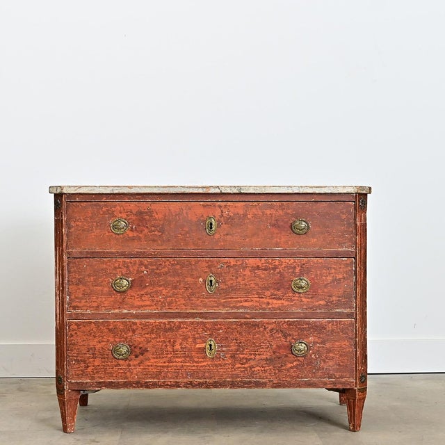 A spectacular three-drawer commode from Sweden, circa 1790, that alludes to a Louis XVI influence met with the pared-down...