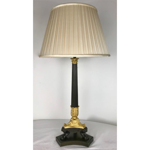 This handsome gilt and patinated columnar lamp base features Classical motifs including acanthus leaves and paw feet.