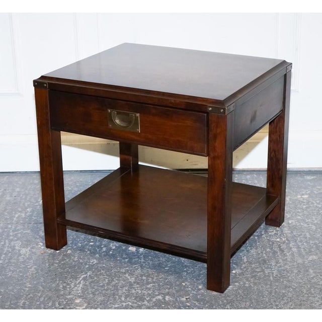 A handsome vintage military campaign nightstand, crafted from rich mahogany and finished with classic brass campaign...