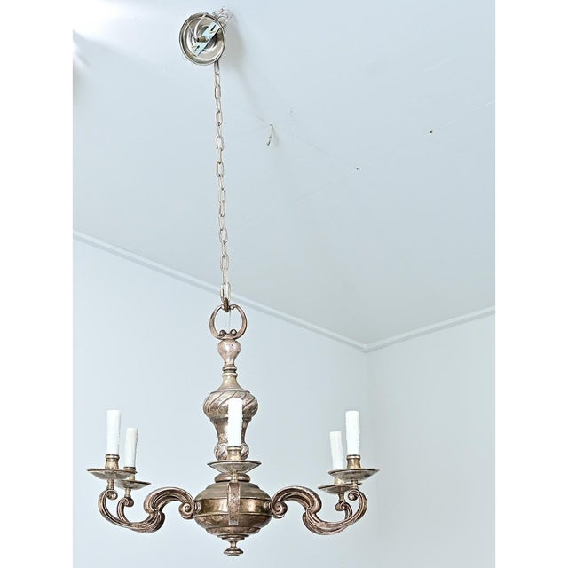 A French silver-gilded brass chandelier with a unique aged patina. The curved forms and undulating lines of this fixture...