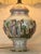 A richly detailed Italian Capodimonte porcelain lamp, adorned with sculpted mythological figures, cherubs, and classical...