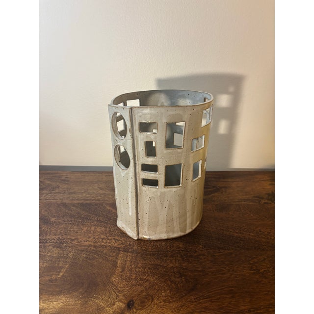 A sculptural 1960s mid-century modern ceramic planter featuring an architectural arrangement of square and circular cutout...