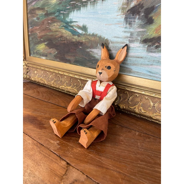 Charming vintage hand-carved wooden rabbit doll, featuring articulated arms and legs with a natural wood finish. The...