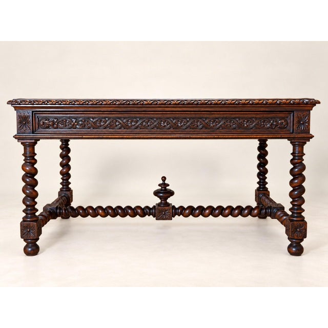 A flat desk in solid dark-stained oak, in the louis xiii style, likely made in the 19th century. the front features two...