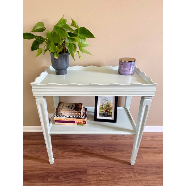 Wooden, two-tier side table refinished in Sherwin Williams’ Rainwashed. This charming piece has enough space to hold books...