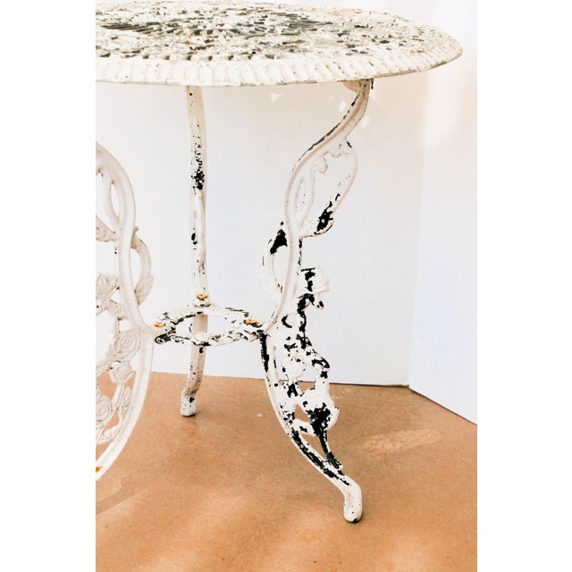 Petite round French style garden table. Made of cast aluminum this table features a beautifully detailed round top adorned...