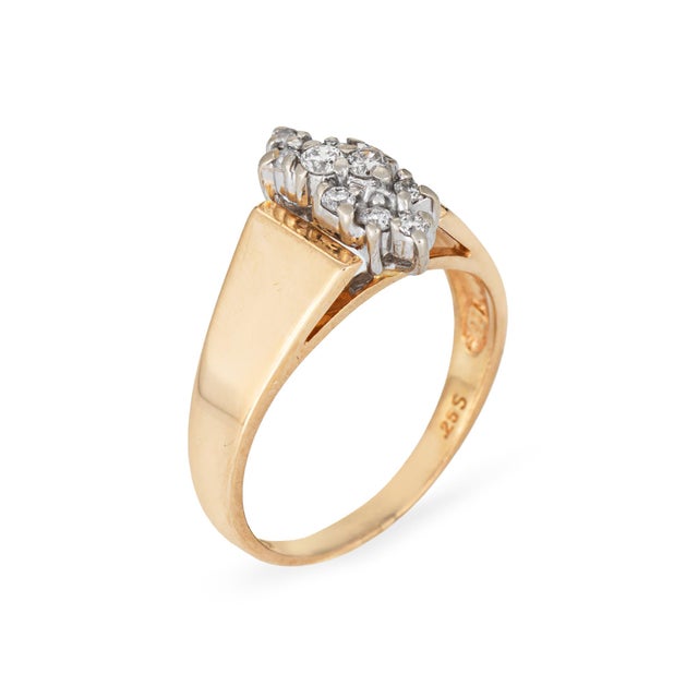 Stylish diamond cluster band crafted in 14 karat yellow gold (circa 1970s). Round brilliant cut diamonds total an...
