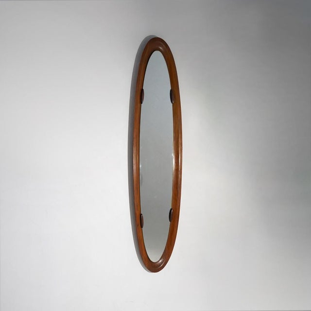 An Italian wall mirror from the 1960s, characterised by a highly elongated oval shape and slender proportions that...