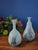 Beautiful pair of vintage Korean celadon vases, each showcasing a graceful hand-painted red orchid and black foliage motif...