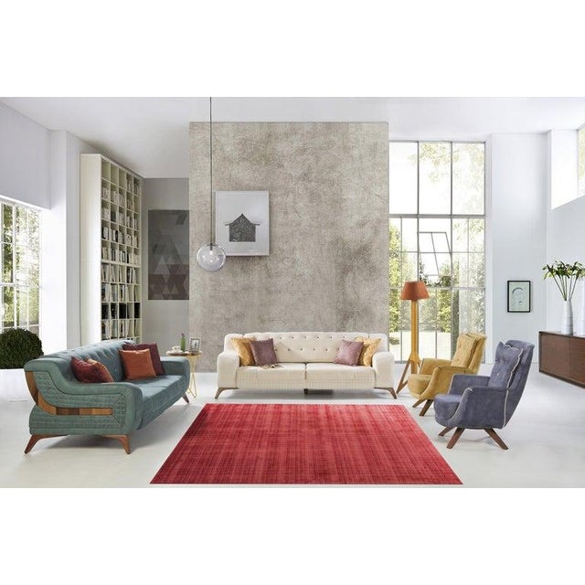 This hand tufted viscose rug features a primary red and rust color palette suitable for a variety of interior settings....