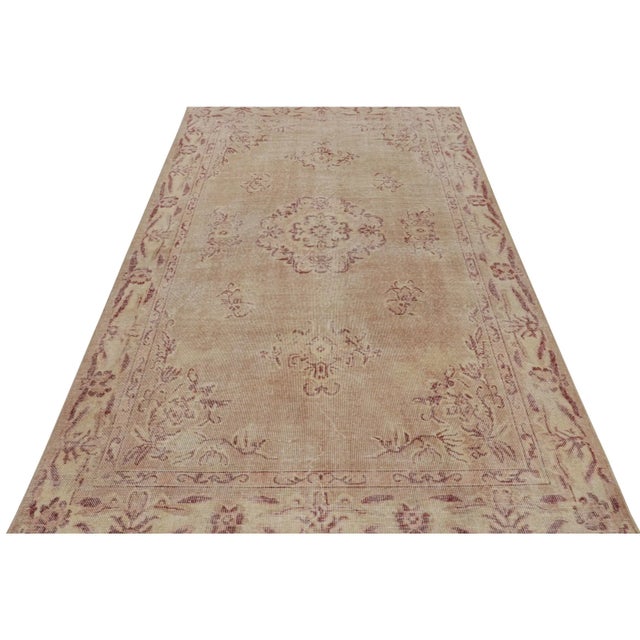 Handknotted in wool, this 6x10 vintage rug originates from Turkey, circa 1960-1970, and is believed to be among the works...