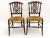 A pair of delicate saber leg side chairs with rush seats, nicely carved and interlaced back splats and turned legs and...