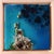 This artwork presents an aerial view of a vibrant ocean landscape, rendered in rich shades of blue and turquoise. The...