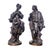 Bronze figures with a brown patina depicting a couple dressed in 18th-century fashion: the young man, leaning against a...