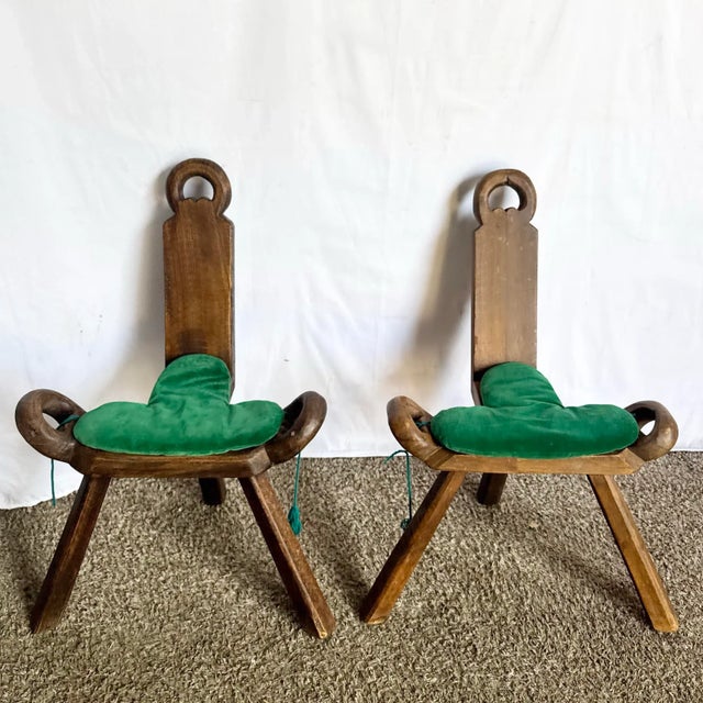 This striking pair of vintage handmade wooden birthing chairs showcases traditional craftsmanship and sculptural artistry....